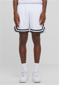 Shorts de sport blancs avec des rayures noires sur les côtés, fabriqués en tissu maillé respirant, dotés d'une taille élastique et d'une coupe décontractée.