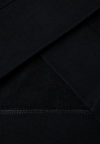 Černá tkanina s hladkými a strukturovanými částmi, s prošívanými okraji. Materiál se zdá být elastický a odolný, vhodný na sportovní oblečení.