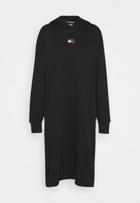 Černé mikinové šaty s kapucí a dlouhými rukávy, s malým logem v červené a bílé barvě. Vyrobené z hladkého, jemného materiálu s bočními rozparky.