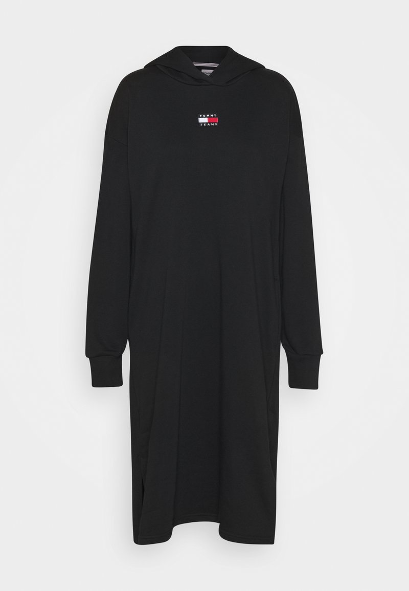 Černé mikinové šaty s kapucí a dlouhými rukávy, s malým logem v červené a bílé barvě. Vyrobené z hladkého, jemného materiálu s bočními rozparky.