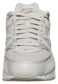 Light gray Nike sneaker featuring a mix of textured leather and mesh, round toe, lace-up closure, and signature logo on the tongue.