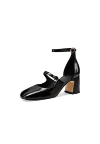 Scarpa nera in vernice con punta quadrata, cinturino alla caviglia e tacco largo. Presenta piccoli accenti hardware circolari.