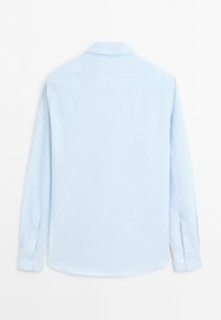 Chemise bleu clair à manches longues avec des rayures verticales discrètes, vue de dos avec un col classique et des poignets boutonnés.