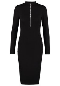 Svart ribbad stickad midiklänning med långa ärmar, hög krage och en silverfärgad dragkedja fram som sträcker sig till mitt på bröstet med en rund dragknapp.