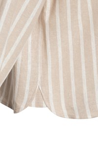 Tessuto a righe beige con strisce bianche, caratterizzato da una trama strutturata e un orlo leggermente curvo. Dettaglio con spacco laterale visibile nella parte inferiore.