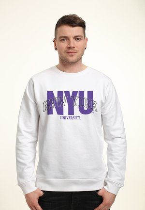 Sweatshirt blanc avec "NEW YORK UNIVERSITY" en lettres violettes en gras. Manches et taille élastiques, texture de tissu douce.