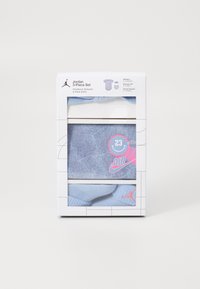 Jordan 3 dalių rinkinys šviesiai mėlyna spalva, kuris apima bodysuitą, galvos juostą ir kojinaites iki kulkšnies. Išskirtinės detalės: rožinės akcentai ir "23" logotipas.