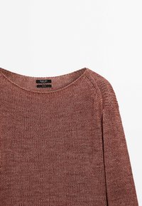 Pull en lin marron tricoté avec encolure ronde et manches longues, posé à plat montrant la partie avant supérieure et les détails de la texture.