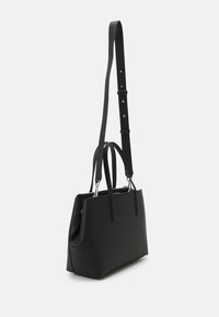 Sac fourre-tout noir au design structuré, fabriqué en matériau lisse. Dispose de deux poignées et d'une bandoulière réglable avec ferrures argentées.