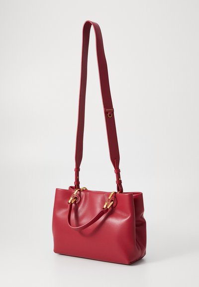 Red leather handbag with a structured shape, featuring a smooth texture, golden hardware accents, and adjustable shoulder straps.