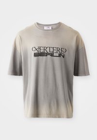 Gray gradient t-shirt with short sleeves, featuring a black print of “VERTERE BERLIN” in a stylized font, soft texture, and relaxed fit.