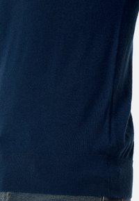 Mörkblå stickad tröja med en slät yta, försedd med ribbad nederkant och ärmslut. Enkel design utan ytterligare mönster eller detaljer.