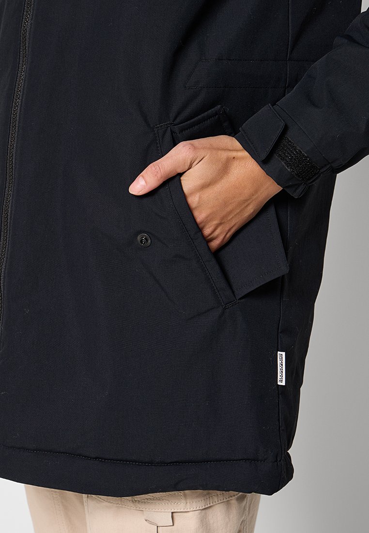 Veste noire imperméable avec fermeture éclair, poche pour les mains et poignets ajustables. Le matériau est texturé et durable.