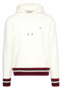Hoodie aus cremefarbenem Stoff mit einer Fronttasche. Mit roten und marineblauen gestreiften Bündchen sowie einem unteren Saum; beinhaltet Zugbänder für die Kapuze.