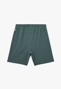 Pantalones cortos deportivos verdes, fabricados con una tela suave, que cuentan con una cintura elástica, longitud hasta el muslo y un pequeño logo en el lado izquierdo.