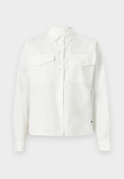 Λευκό πουκάμισο με μακριά μανίκια και κουμπιά, με τσέπες στο στήθος και κλασικό γιακά, τοποθετημένο επίπεδα σε ανοιχτό φόντο.
