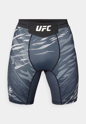 Czarno-szare spodenki sportowe z białymi, abstrakcyjnymi wzorami. Charakteryzują się dopasowanym krojem i elastycznym pasem w talii z logo UFC.
