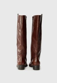 Brown leather knee-high boots with a smooth finish, showing zippers on the inner sides and a stacked heel, displayed against a plain background.