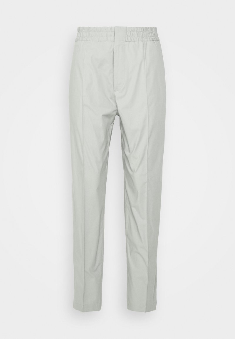 Světle šedé kalhoty s elastickým pasem, mají rovný střih a hladkou texturu látky, bez viditelných vzorů nebo kovových doplňků.