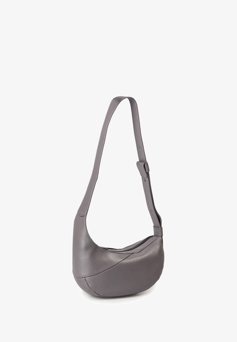 Gray leather shoulder bag with a curved design, adjustable strap, and seamless accent stitching. Features a zippered closure.
