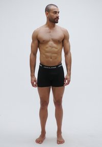 Melnas kokvilnas bokseršorti ar piegulošu dizainu un elastīgu jostasvietu ar baltā krāsā rakstīto zīmola nosaukumu "JACK & JONES".