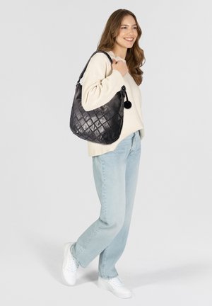 Sac hobo en cuir matelassé noir avec une forme arrondie, fermeture éclair supérieure et un accent en forme de charme circulaire. Design léger et texturé.