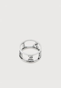 Inel deschis argintiu cu cuvântul „LOVE” scris cu litere mari în jurul benzii sale pe un fundal alb simplu.