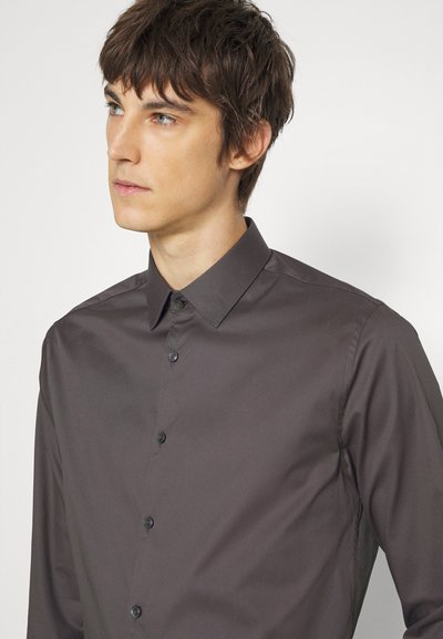 Camisa de botão cinza escuro com um colarinho clássico, feita de tecido liso, apresentando um corte ajustado e botões pretos visíveis.