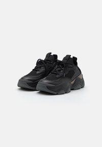 Black athletic shoes with a textured mesh upper, padded collar, thick rubber sole, and contrasting gray accents on the side.