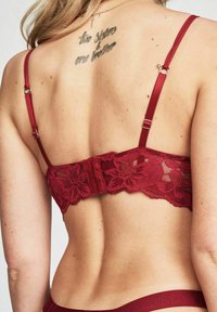Bordeaux Spitzen-Bralette mit verstellbaren Satin-Trägern, Blumenmuster, Haken- und Ösenverschluss und gewelltem Saum am unteren Rand.