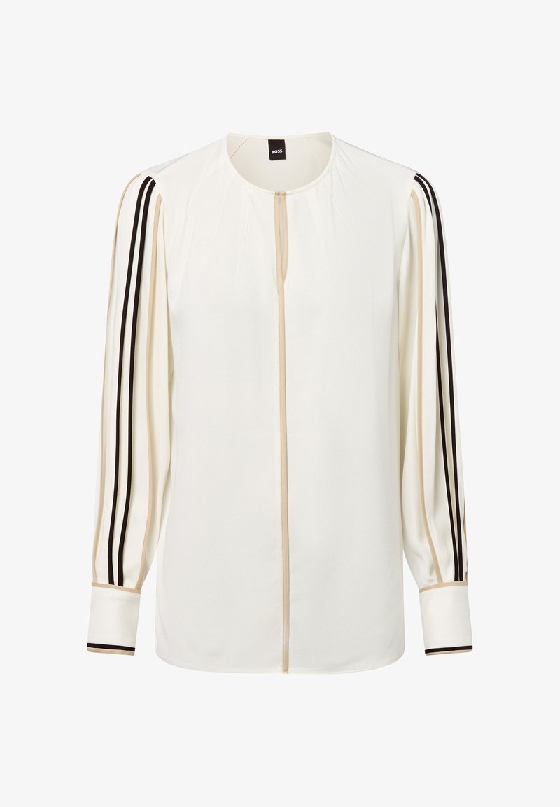 Weiße Bluse mit langen Ärmeln, mit beigen und schwarzen Streifen entlang der Ärmel und in der Mitte, runder Ausschnitt und mit Manschetten.