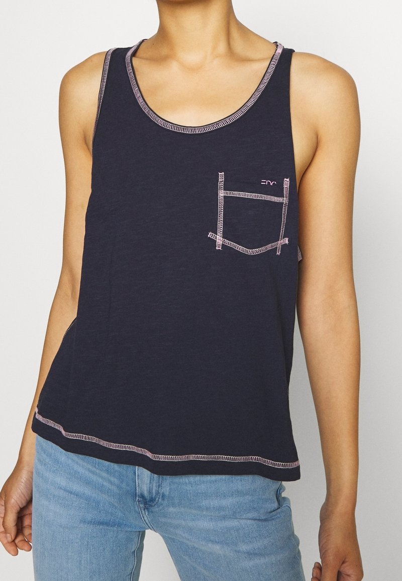 Marineblauw tanktop met een ronde halslijn, roze stiksel en een klein borstzakje. Gemaakt van zachte stof, ideaal voor casual kleding.