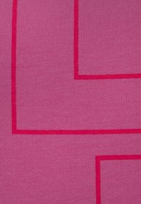 Un tissu rose vif présentant des lignes géométriques rouges en relief créant un motif. La texture est nervurée, mettant en évidence le contraste du design.