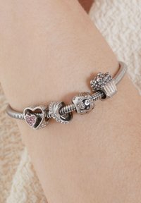 Zilveren armband met bedels, waaronder een fonkelend hart, cupcake en een sterpatroon-kraal met zirkonia-accenten.