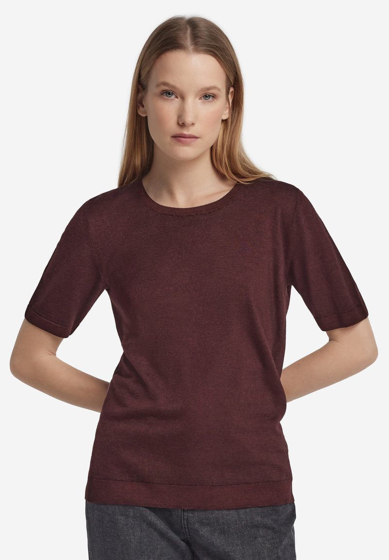 Burgundröd kortärmad tröja med rund halsringning, slät textur och uppvikta ärmslut. Klassisk figursydd design och ribbad fåll detalj.