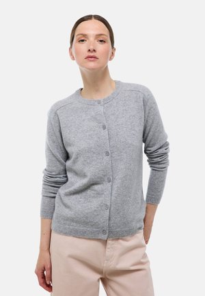 Cardigan en laine gris avec un col rond, une fermeture à boutons, des poignets côtelés et une texture lisse, associé à un pantalon rose clair.