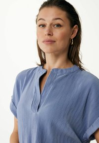 Top corto de manga corta en azul claro con textura acanalada y cuello con muesca. Fabricado en una tela suave con una silueta relajada.