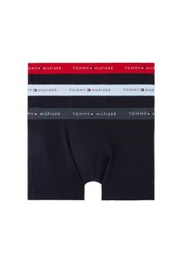 Cuatro pares de calzoncillos tipo boxer para hombre en negro, rojo, gris y azul claro. Cada uno presenta una distintiva banda elástica con el logo "TOMMY HILFIGER".