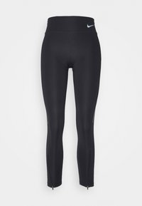 Leggings deportivos negros con una cintura alta, fabricados con una tela elástica, que cuentan con cremalleras en los tobillos y un pequeño logo multicolor.