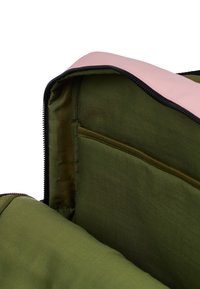 Green fabric bag with a pink zipper. Interior features a zippered pocket and smooth lining. Materials appear durable and lightweight.