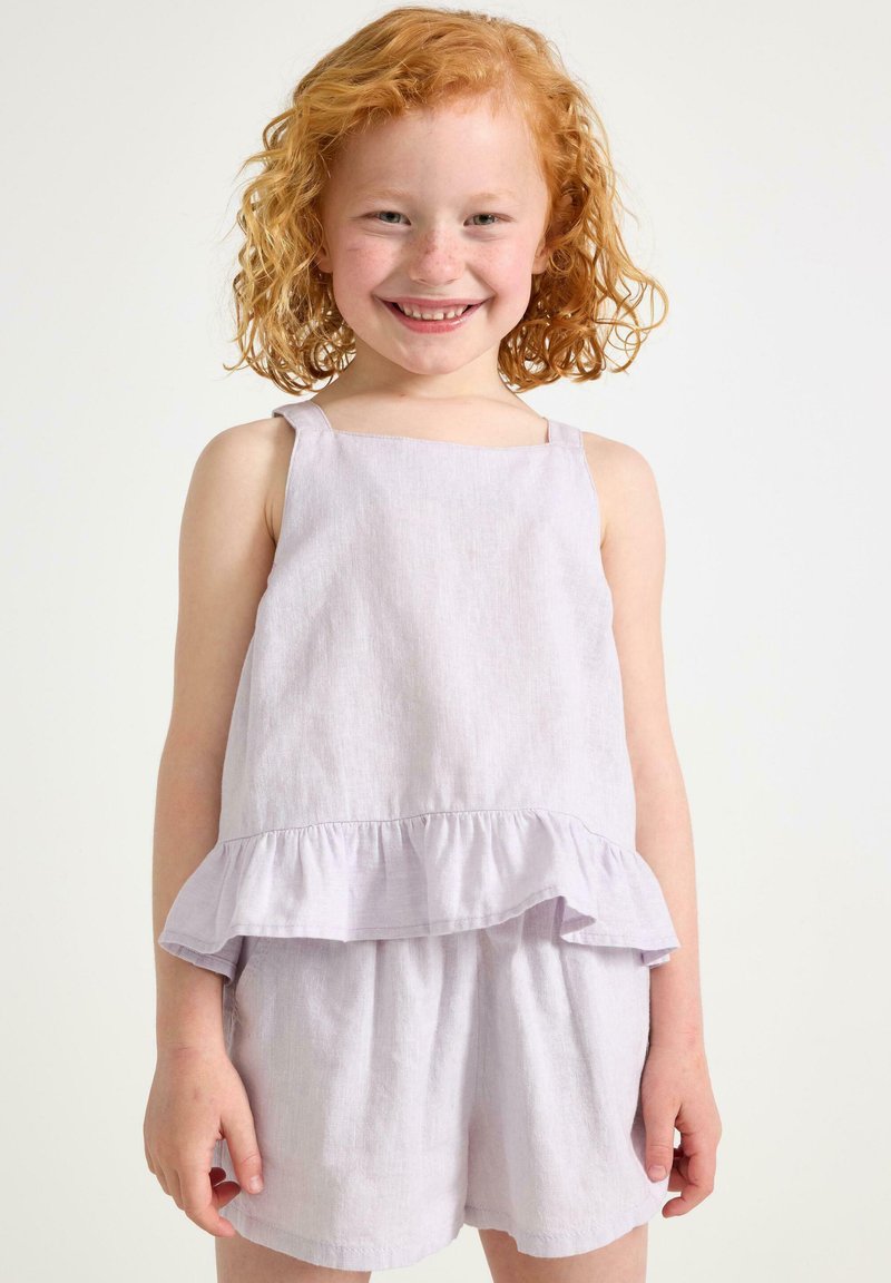 Lillac-linen romper dengan desain peplum berkerut, tali tipis, dan celana pendek dengan pinggang elastis. Tekstur halus dan gaya kasual.