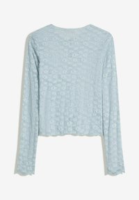 Maglietta a maniche lunghe di colore azzurro chiaro, realizzata in tessuto texturizzato, con un motivo floreale e un design cropped con orlo a scallop.