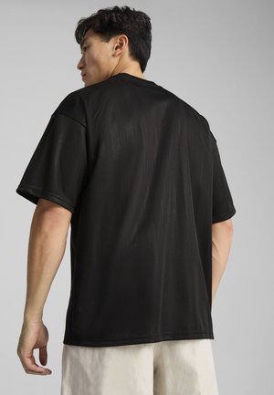 Sort t-shirt med korte ærmer i løstsiddende pasform, lavet af glat stof med subtile vertikale striber. Rund halsudskæring og syet kant.