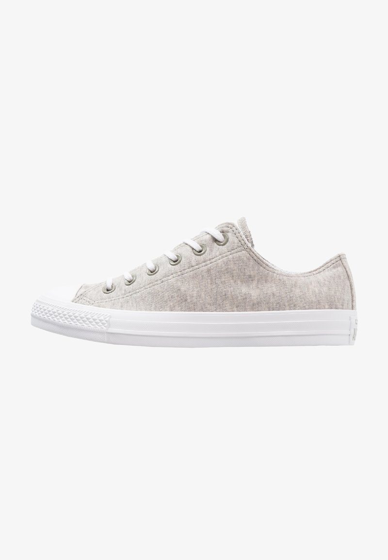 Beige canvas sneakers med vit gummisula, rund tå och metallöglor. Utrustad med vita snören och texturerad tyg. Lågprofil design.