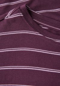 Lila T-shirt med vandrette striber i lys rosa, rund halsudskæring og blød bomuldsstruktur. Synlig sømdetalje.