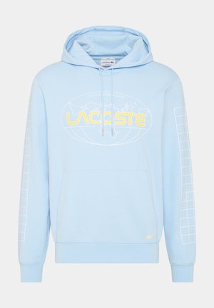 Helles blaues Kapuzensweatshirt mit einer vorderen Kängurutasche. Mit gelbem Text über der Brust und weißen Rautenmuster auf den Ärmeln.