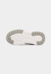 Σόλα παπουτσιού με λευκό και γκρι πέλμα από καουτσούκ που διαθέτει γωνιαία, γεωμετρικά σχέδια για πρόσφυση στις περιοχές των δακτύλων και της φτέρνας.