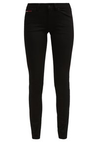 Vaqueros de mezclilla negra con un corte ajustado, diseño de cinco bolsillos y un sutil acento rojo en el bolsillo frontal. Textura suave y estilo clásico.