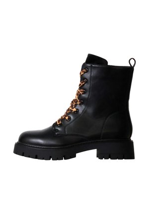 Bottine en cuir noir avec semelle crantée épaisse et lacets imprimés léopard, vue de profil, avec une languette à l'arrière.