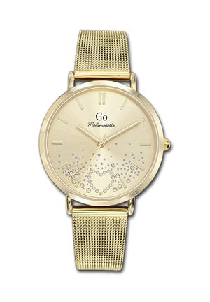 Montre avec bracelet en maille dorée, à cadran rond, indicateurs horaires clairs, et un design scintillant arborant un dégradé de petits cristaux en bas.
